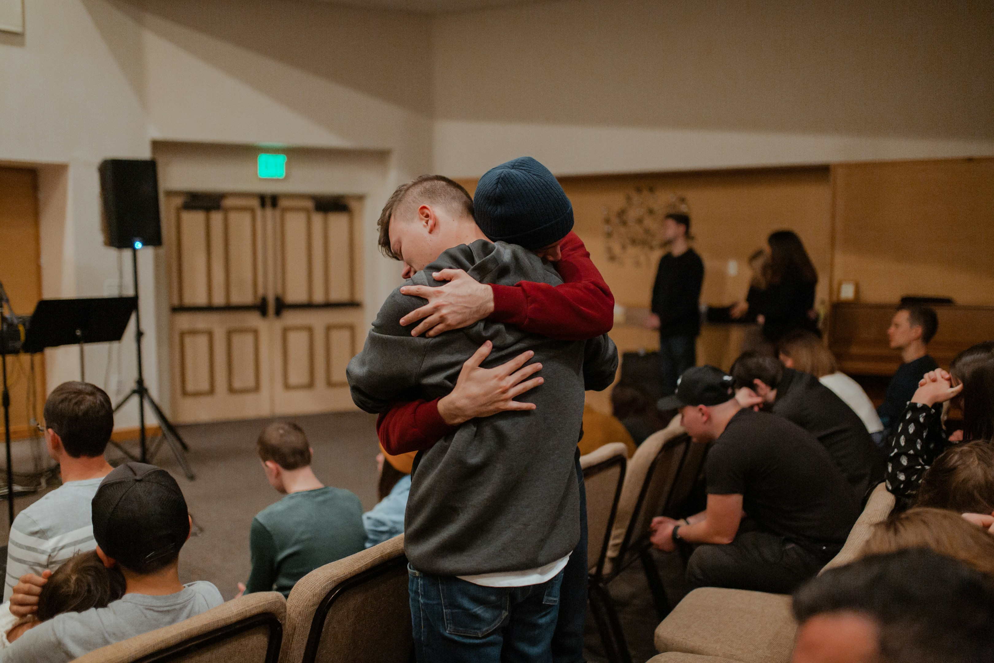 Men embracing at a recovery meeting